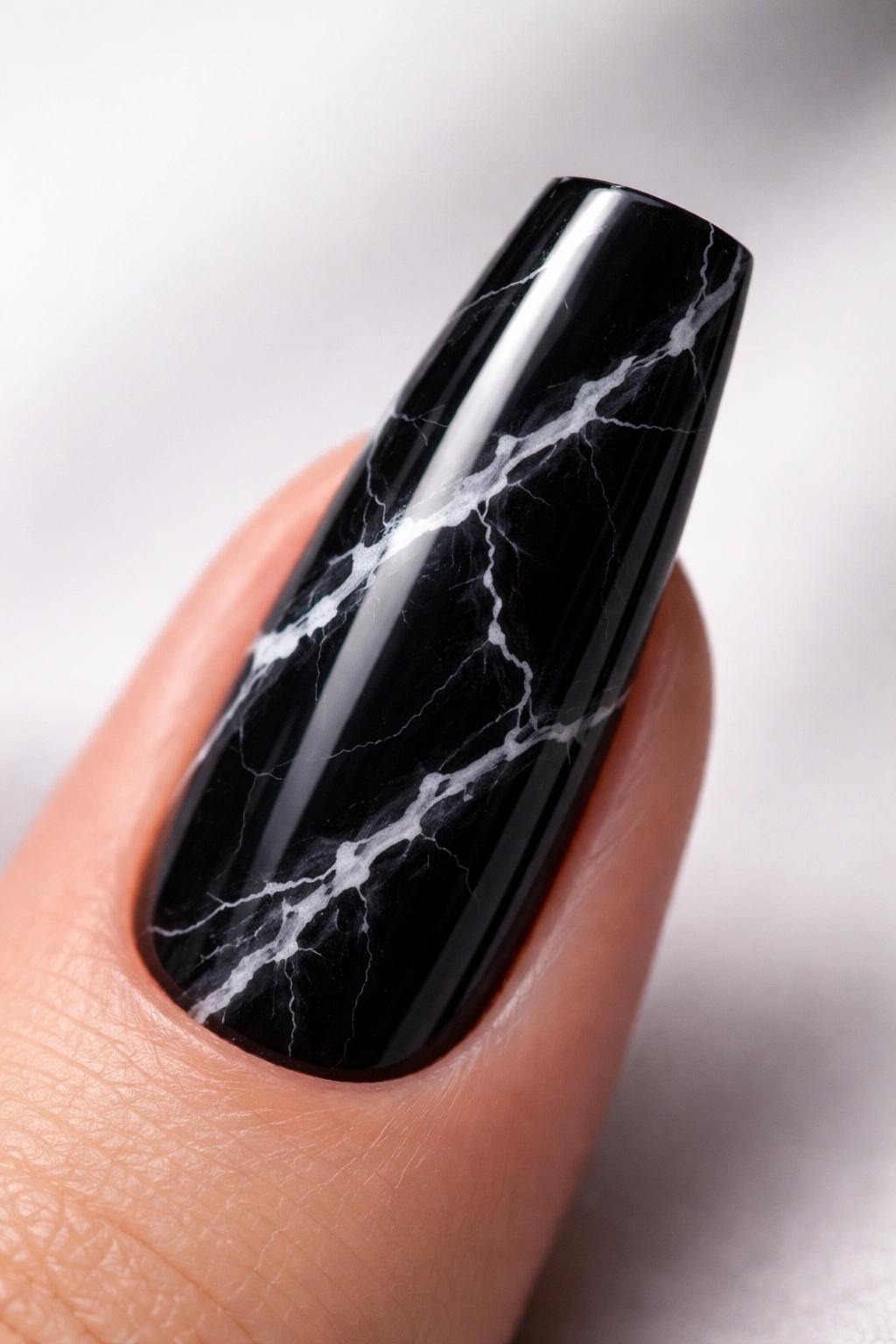 Close-up of black coffin nail with white marble vein pattern