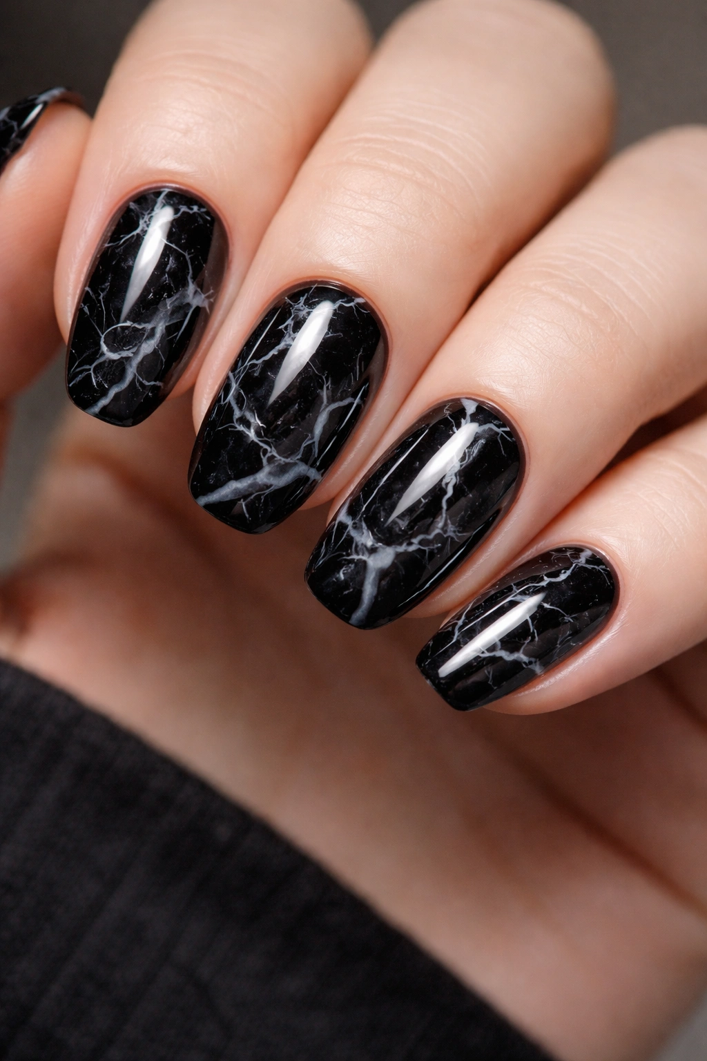 Close-up of black marble nails with white gray veins