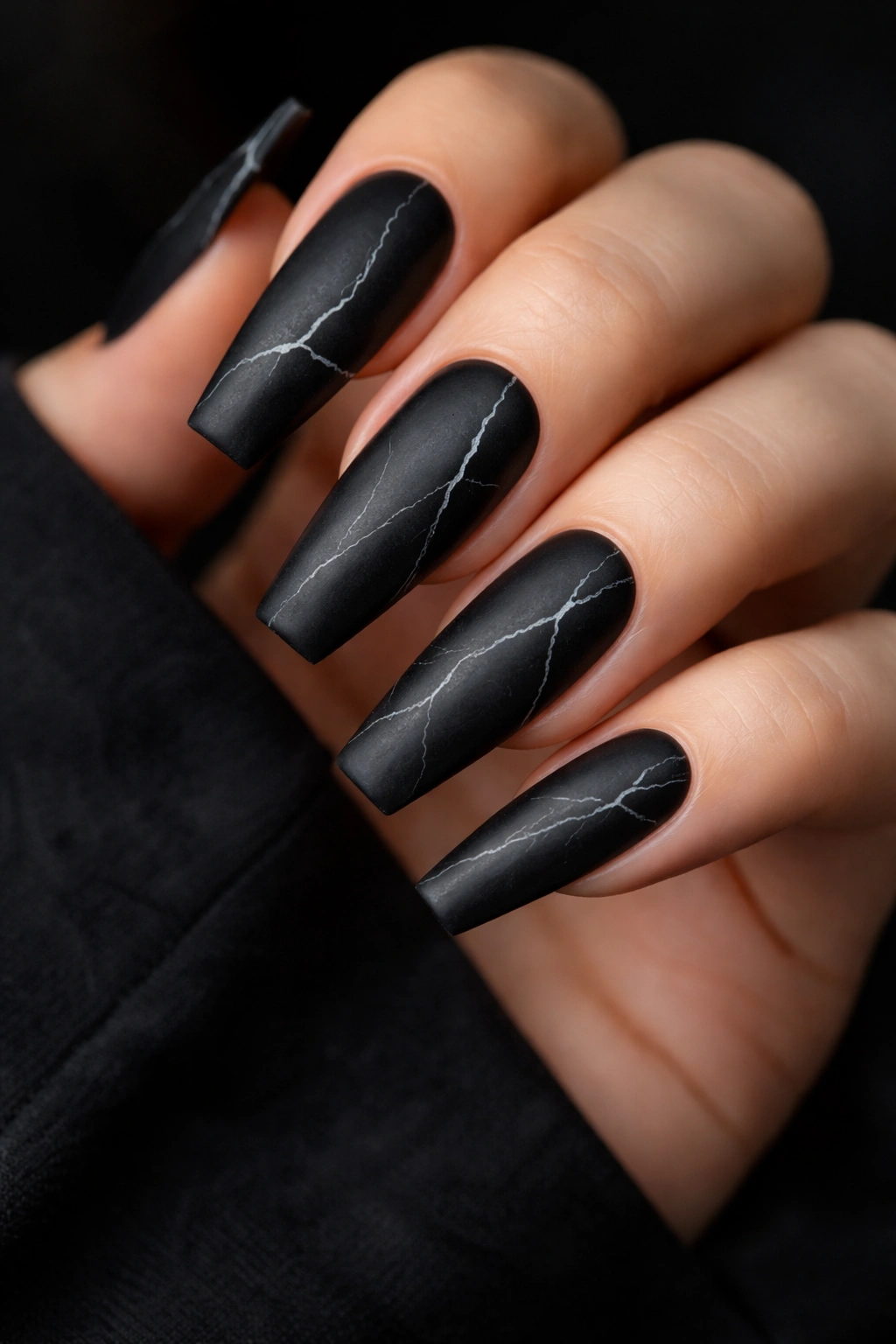 Close-up of black marble nails with white veins