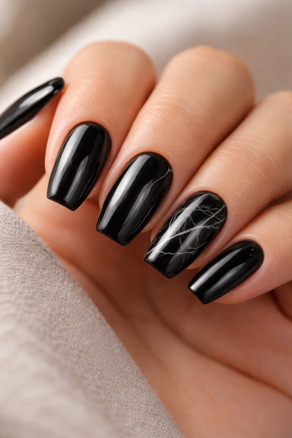 Close-up of black marble nails with hairline white veins on short ballerina nails