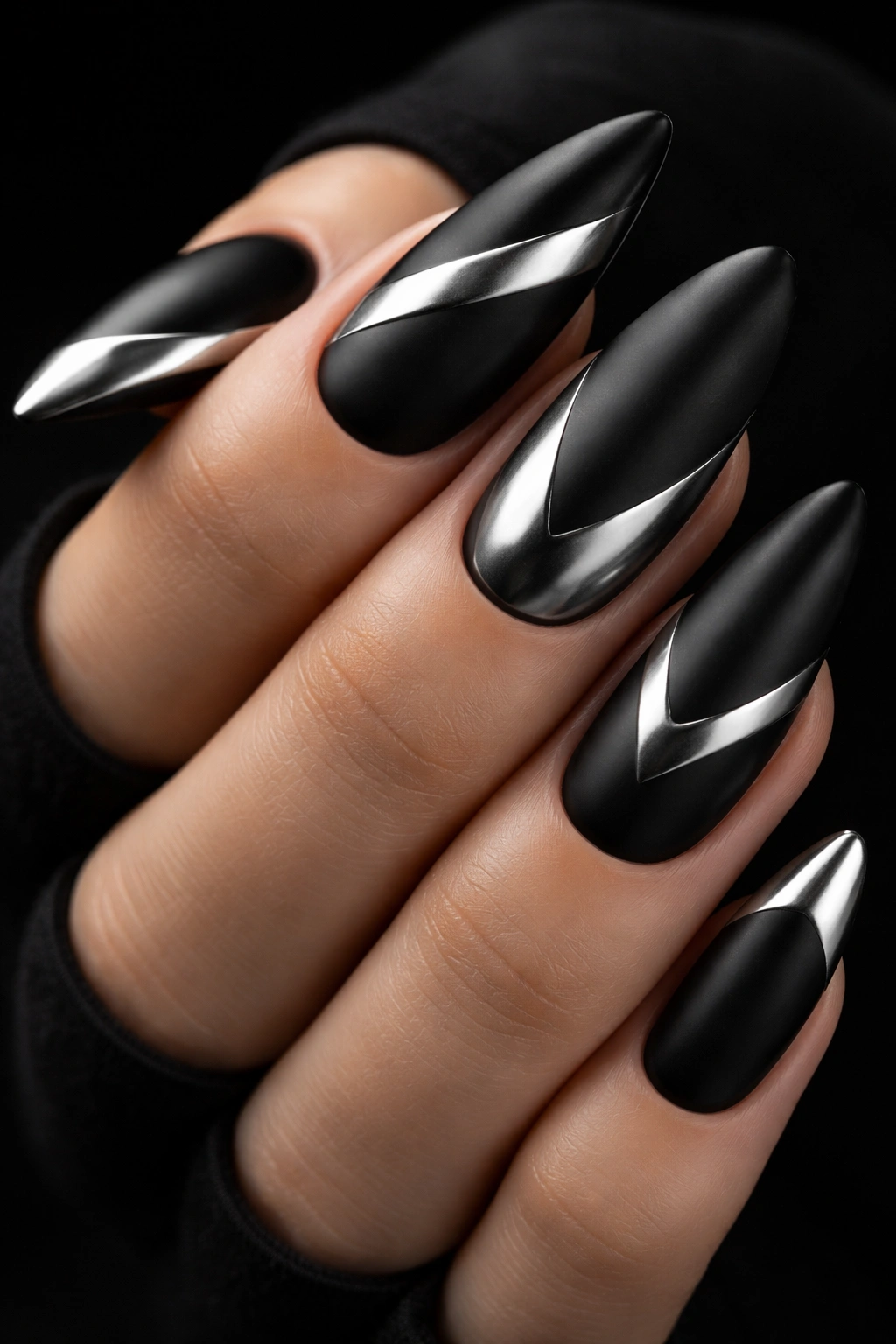 Close-up of black nails with matte chrome accents in geometric shapes