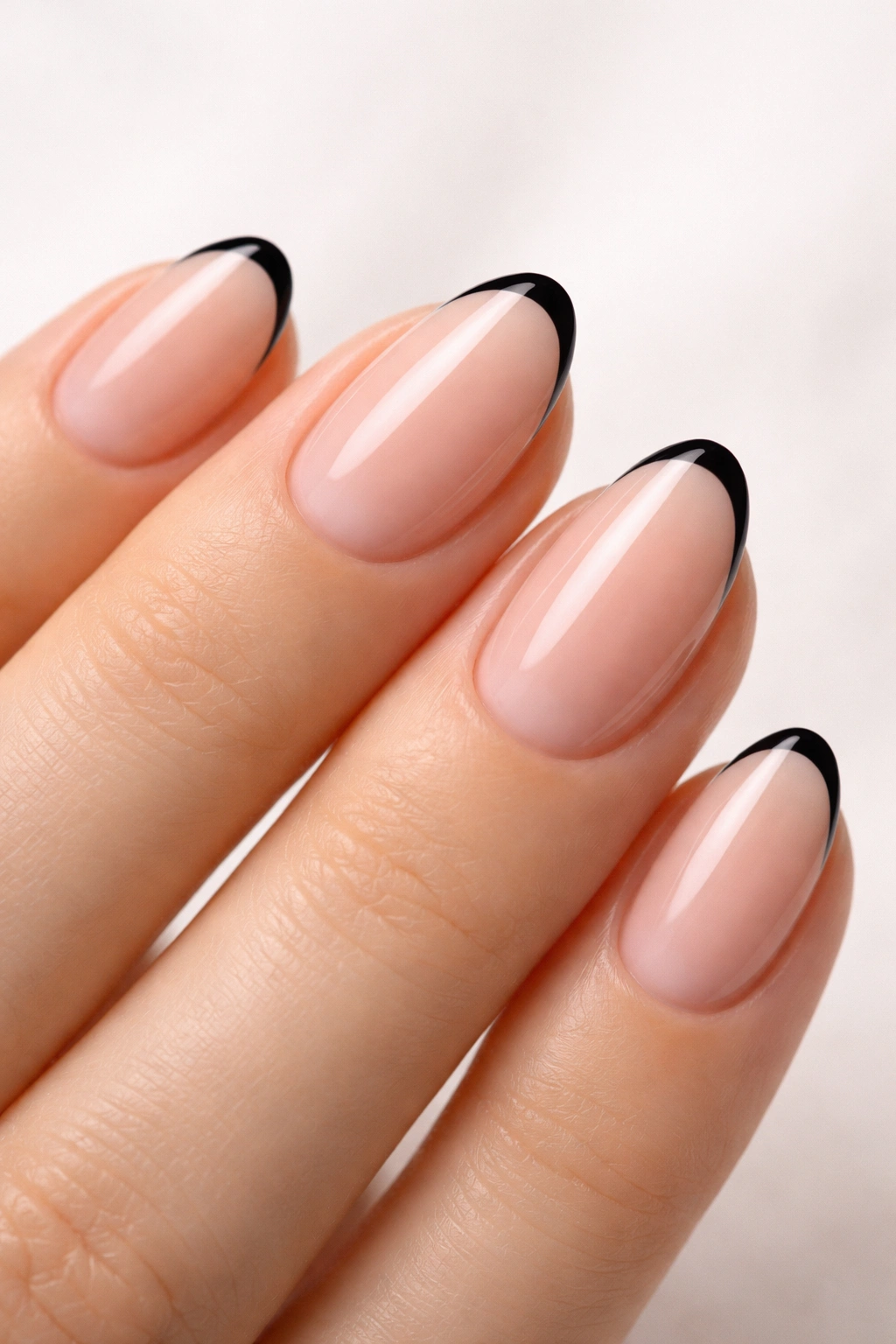Close-up of almond nails with ultra-thin black tip line