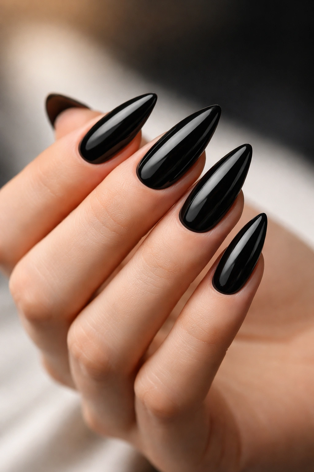 Almond nails painted black with matte or glossy finish