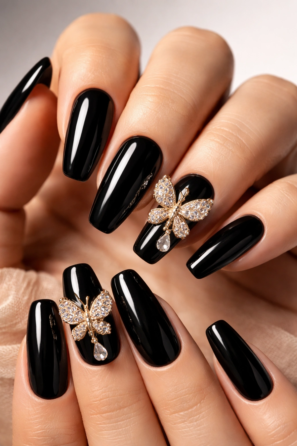 Glossy black nails with butterfly charms on accent nails