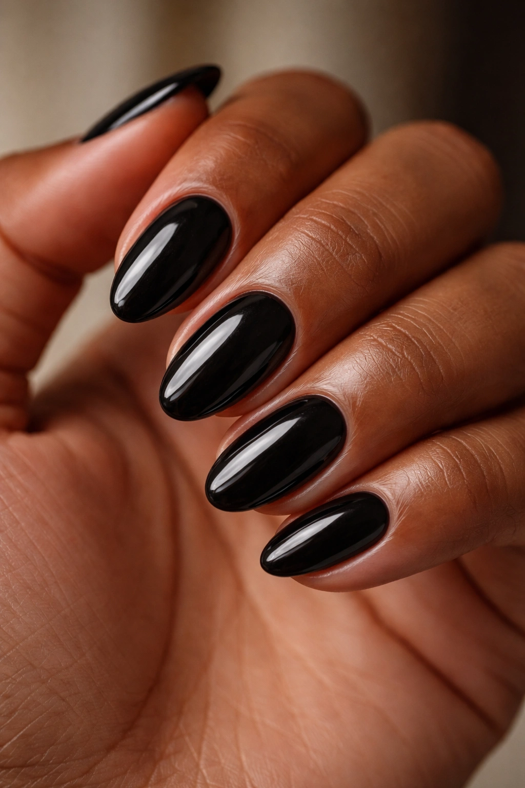 Close-up of clean glossy black nails on short almond nails