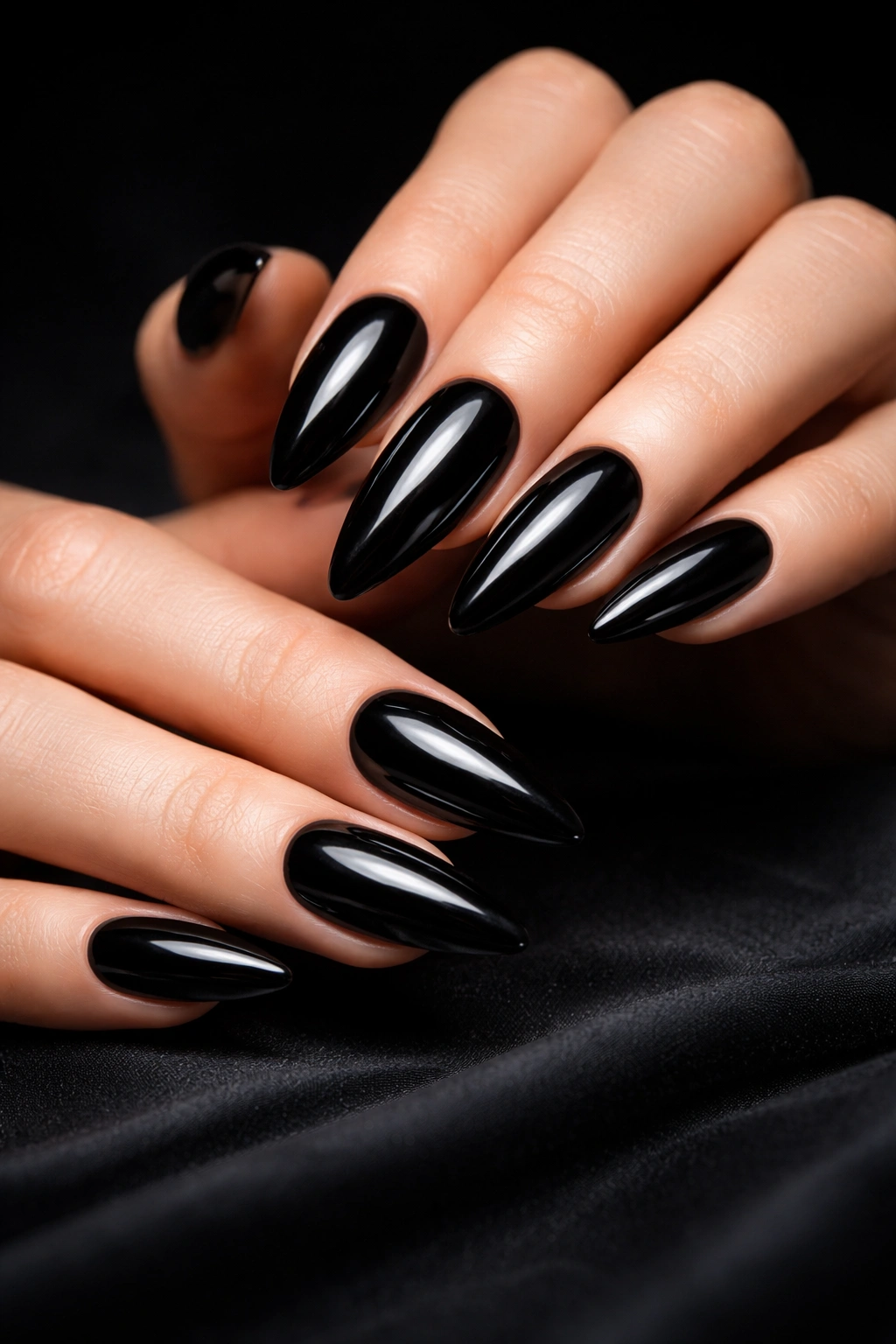 Close-up of glossy black nails against a dark background
