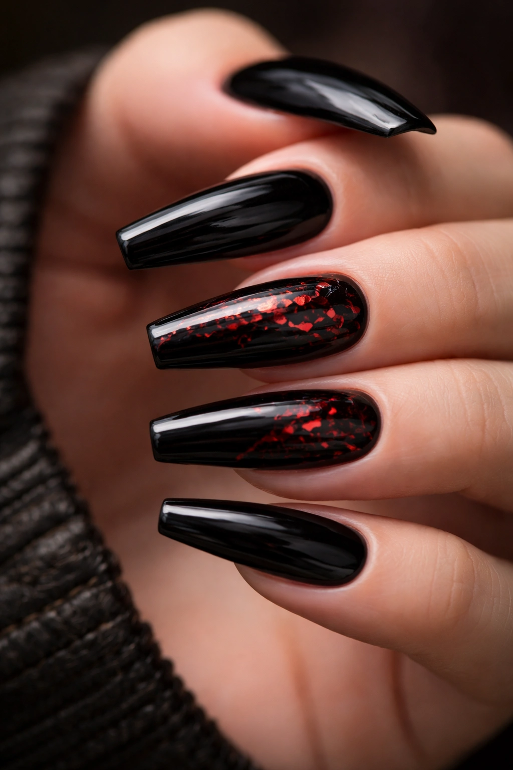 Glossy black nails with red foil cracks.