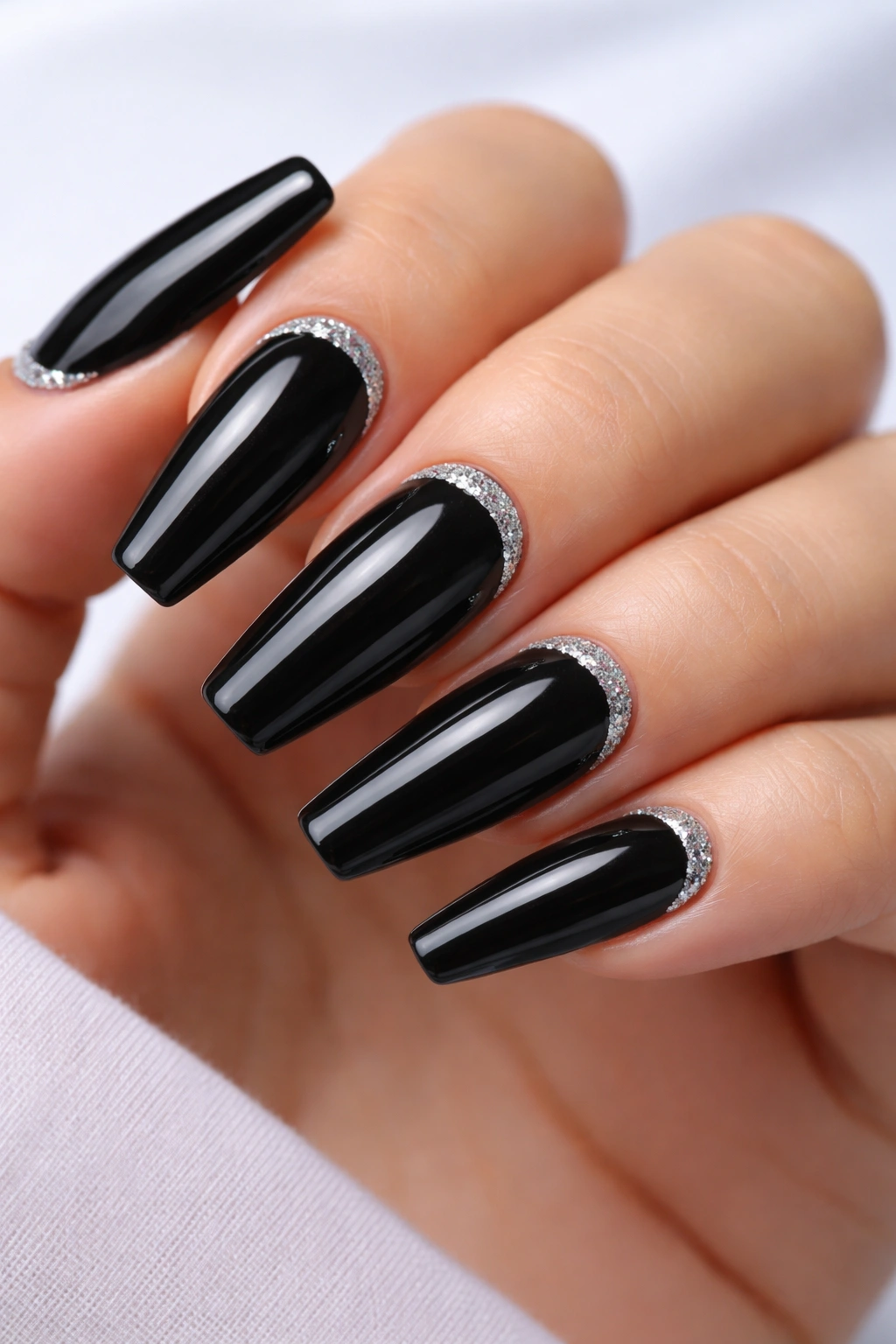 Close-up of black ballerina nails with a single glitter cuticle arc