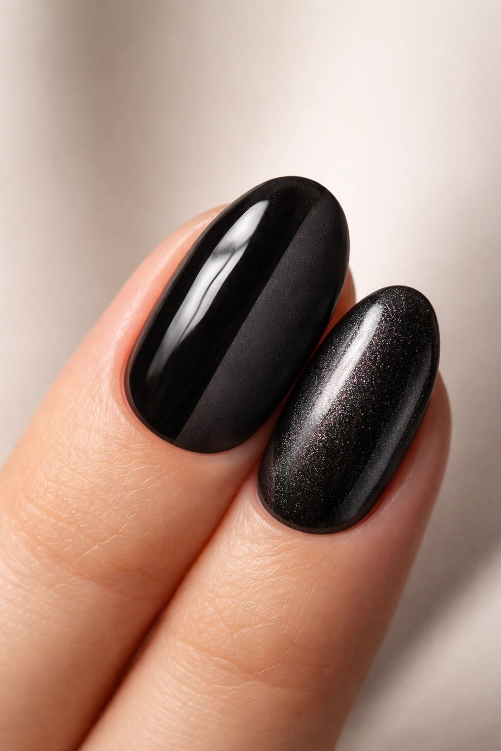 Close-up of a short oval nail showing glossy, matte, and chrome/shimmer black finishes