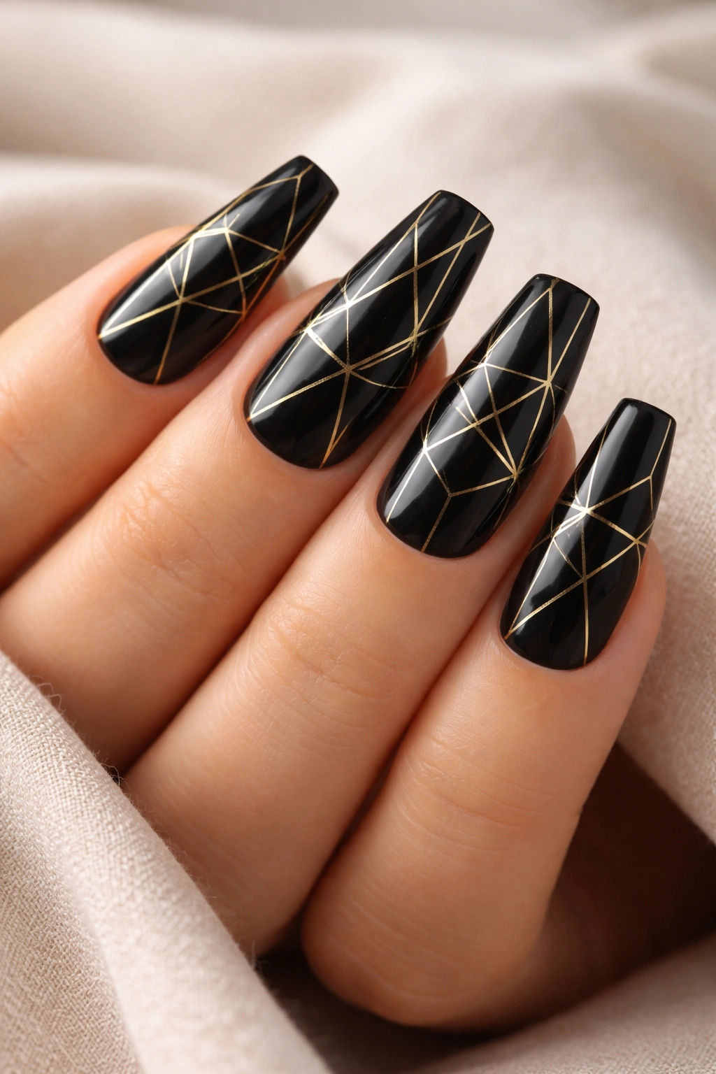 Black coffin nails with fine gold geometric lines.