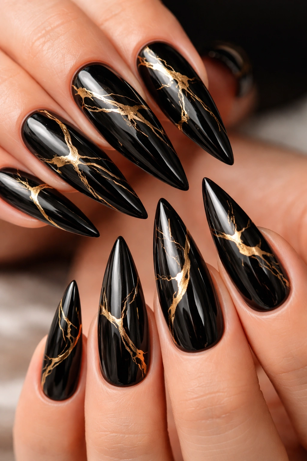 Glossy black nails with hand-painted gold marble veining