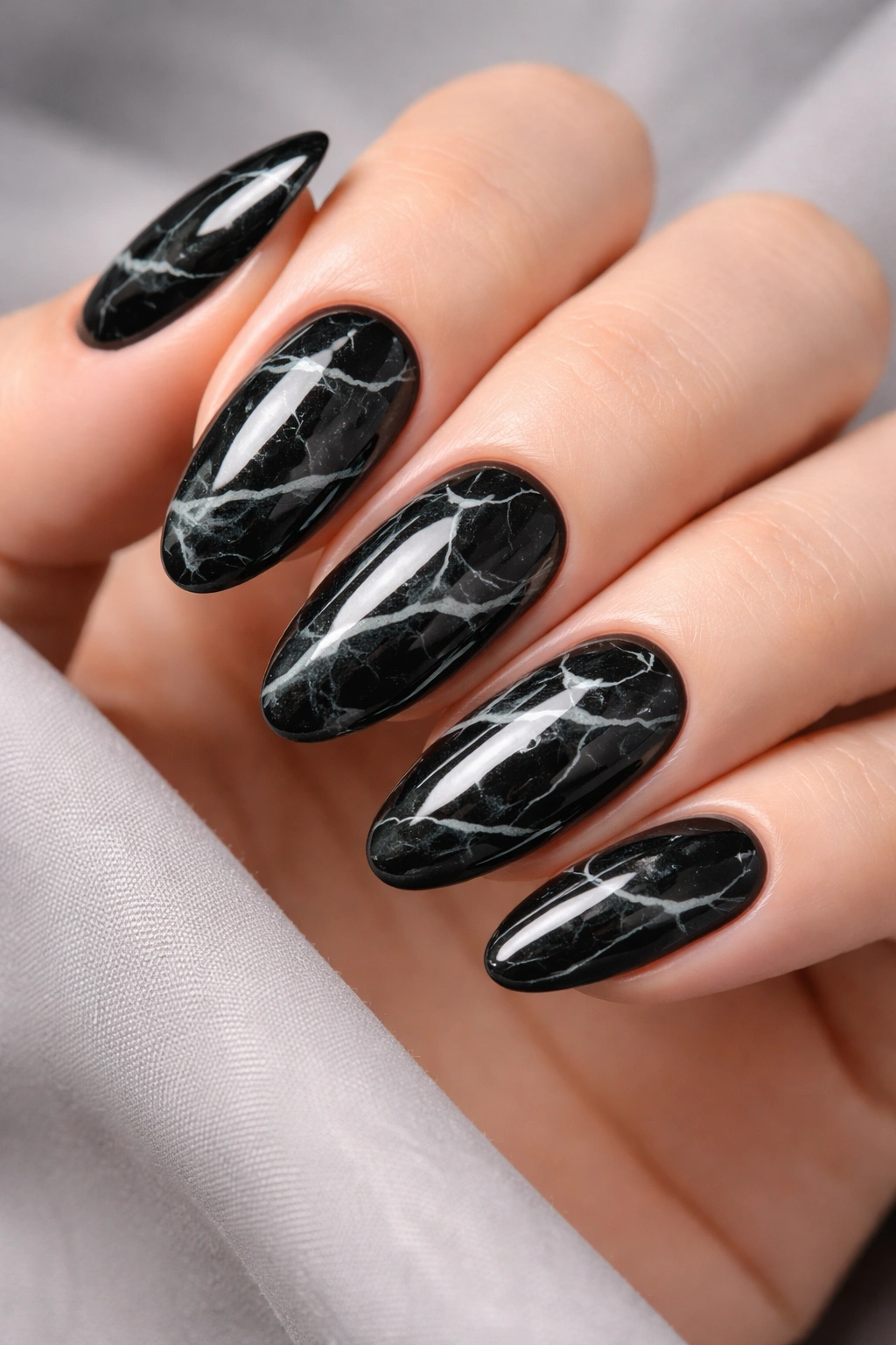 Close-up of black nails with white and gray marble veining