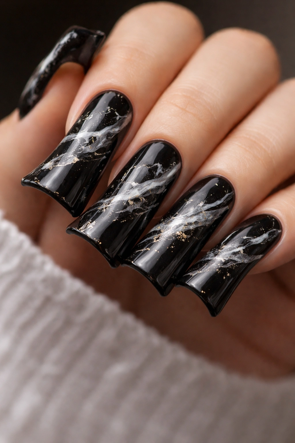 Close-up of black duck nails with marble effect