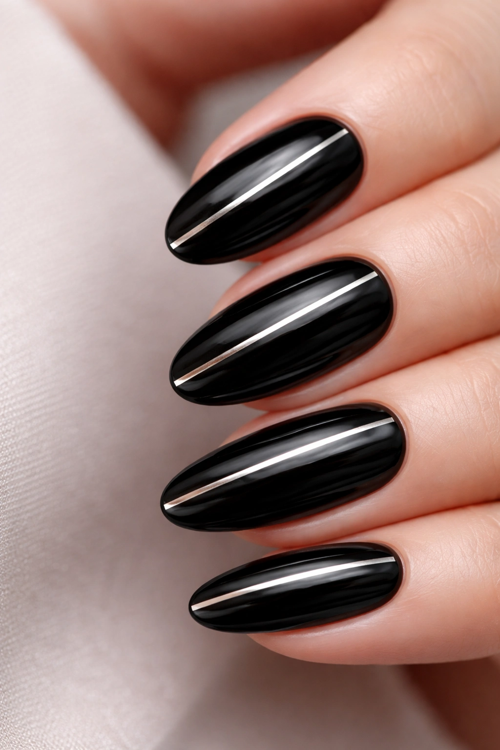 Close-up of black nails with thin metallic stripes running vertically