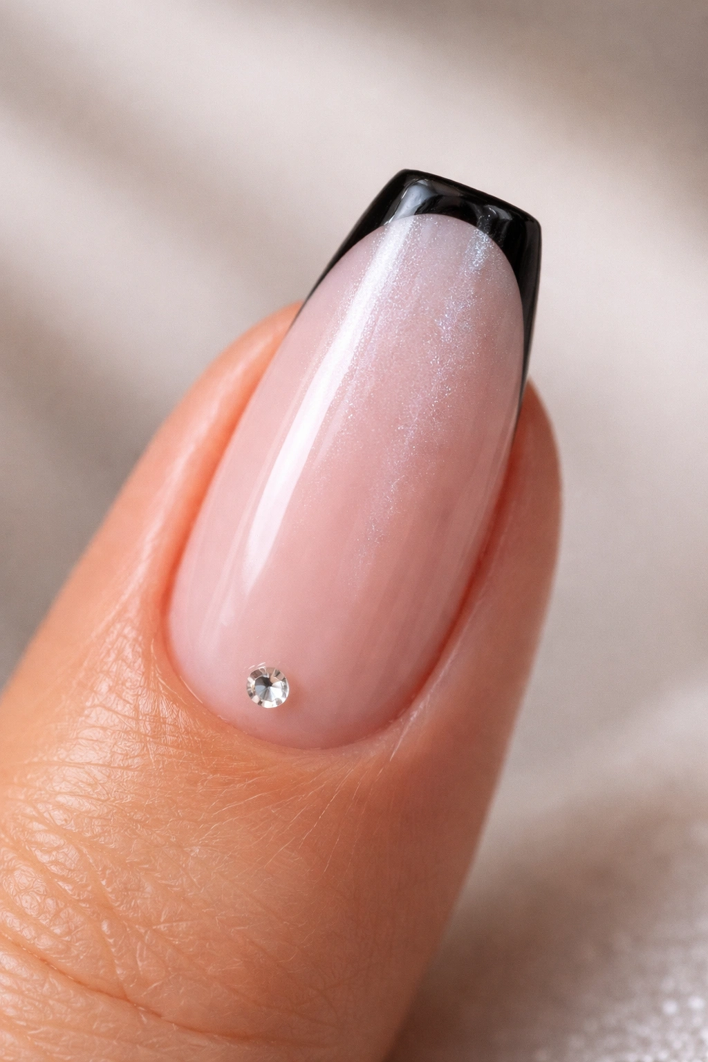 Close-up of black micro-French nails with icy pearl top coat on nude base