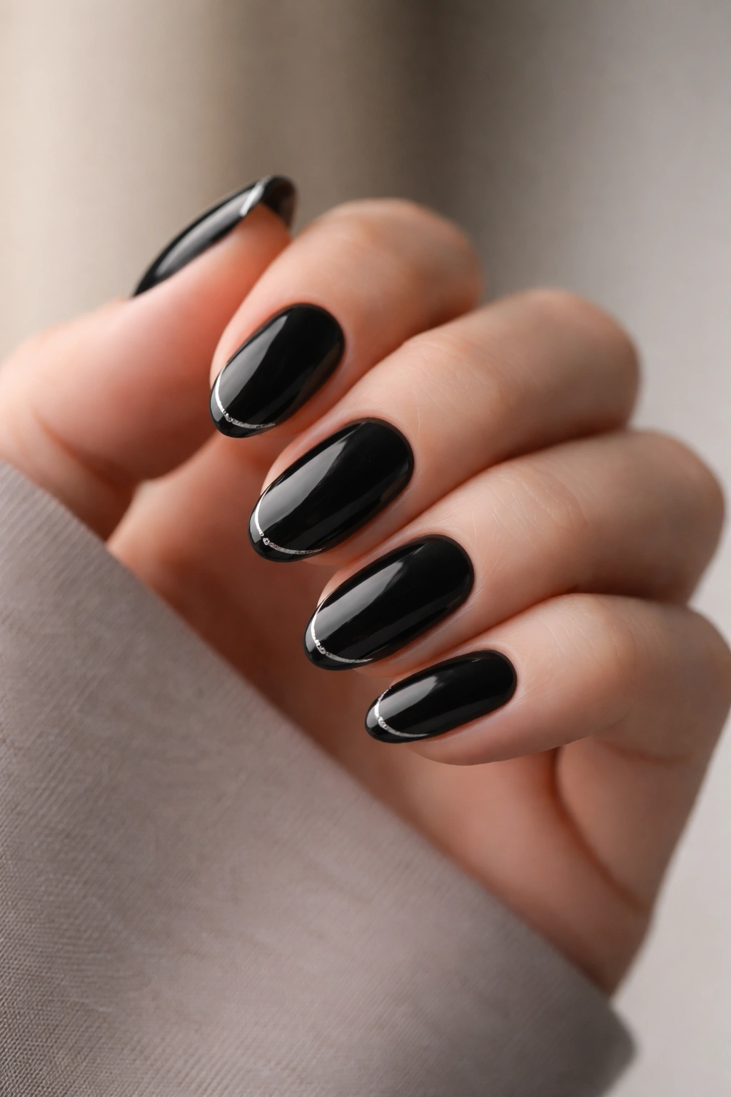 Close-up of black almond nails with tiny silver micro French tips
