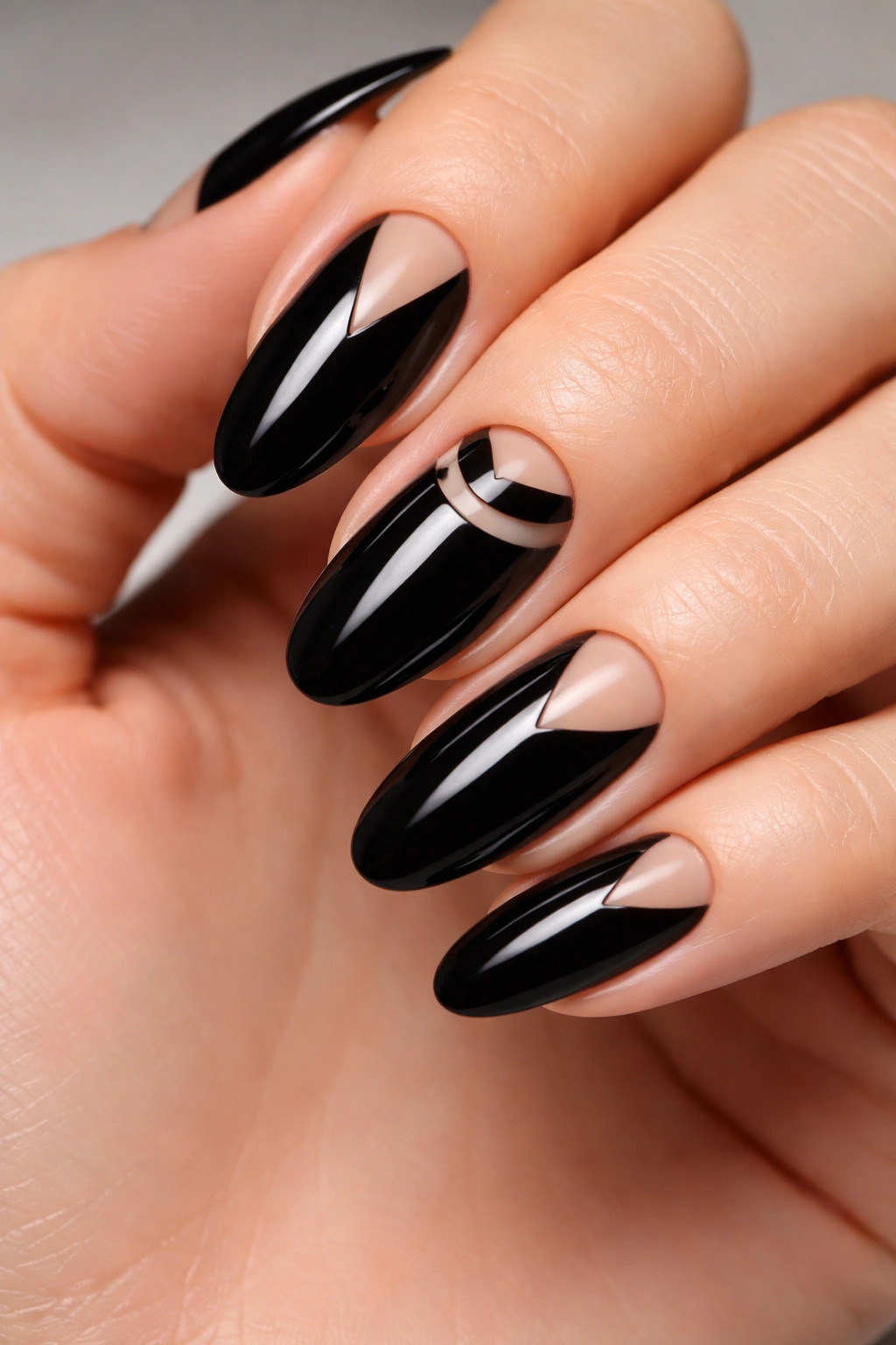 Glossy black long oval nails with negative space geometric shapes