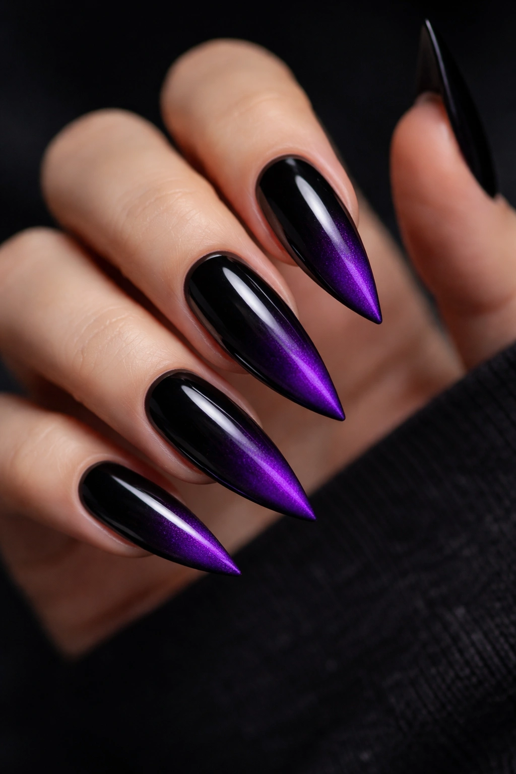 Close-up of black stiletto nails with gradient purple tips