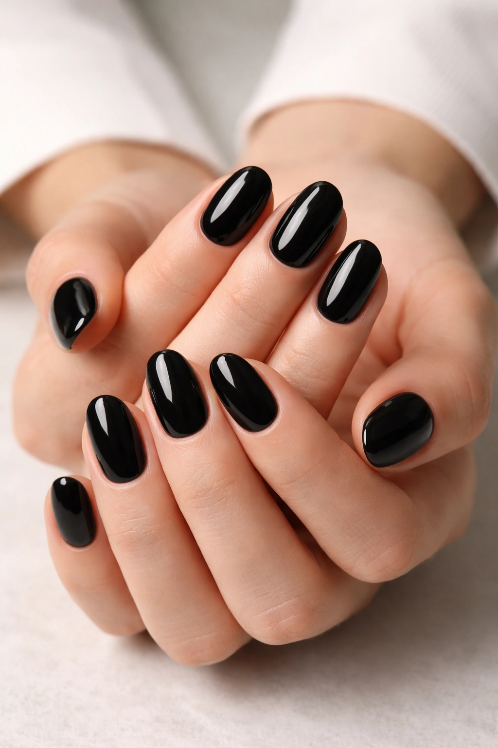 Close-up of black glossy short oval nails on hands