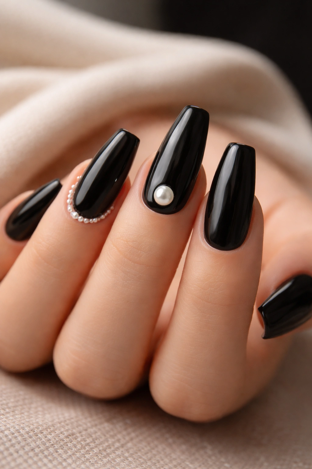 Glossy black coffin nails featuring pearl accents.