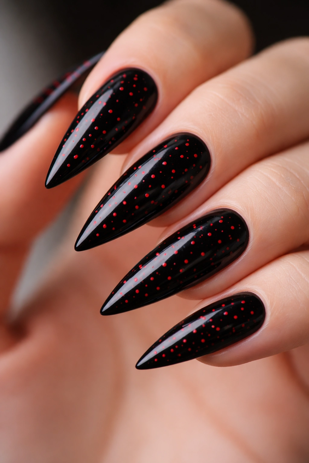Black nails with tiny red micro-dots across surface