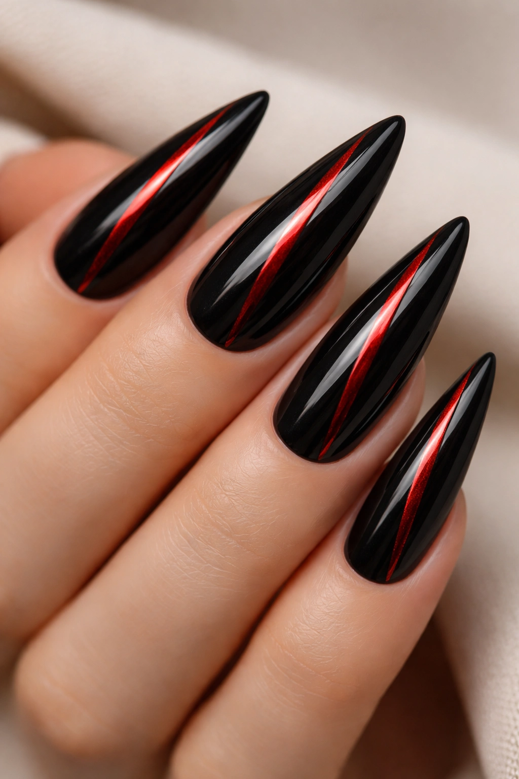 Stiletto nails black base with metallic red stripes