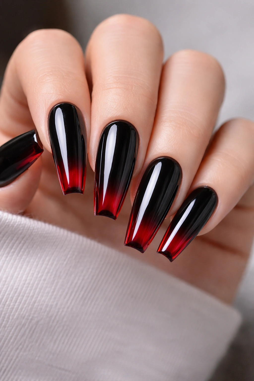 Patent black nails with translucent red glass tips on ballerina nails