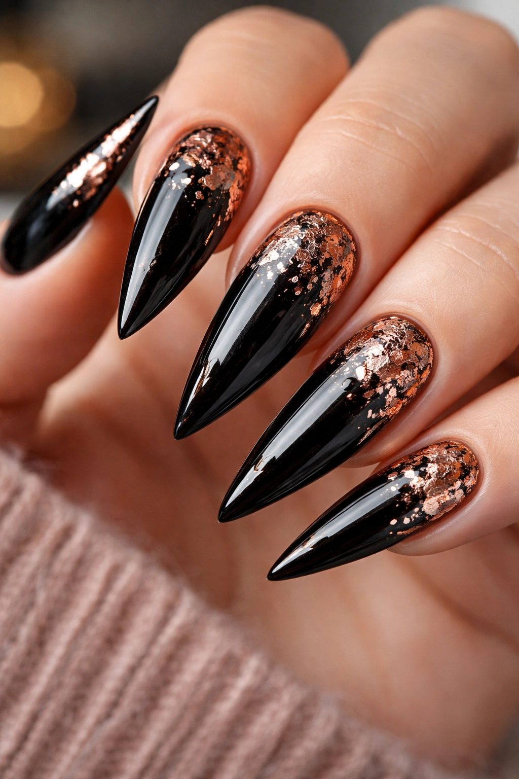 Glossy black nails with rose gold foil accents catching light