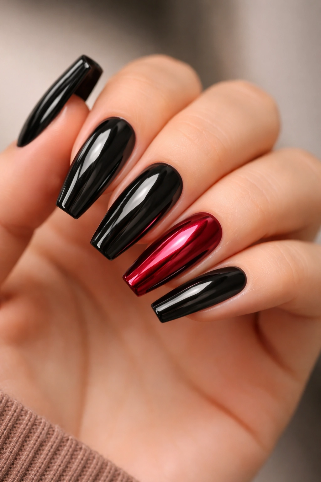 Close-up of black nails with one ruby chrome accent nail