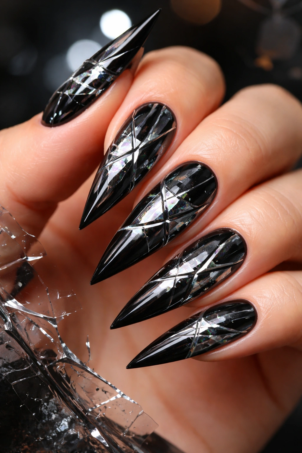 Close-up of black stiletto nails with shattered-glass lines
