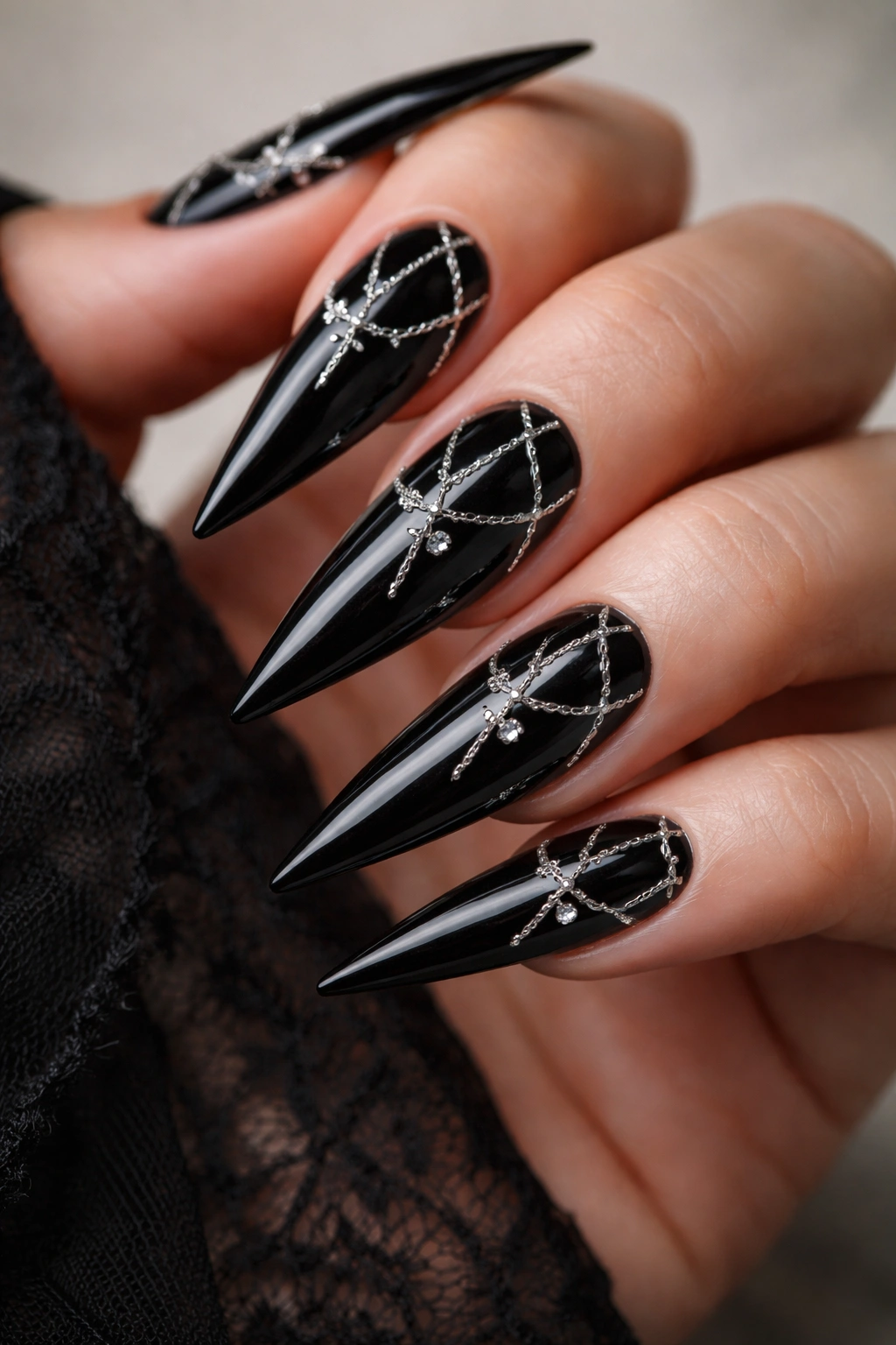 Black nails with delicate silver chains and small crosses on each nail
