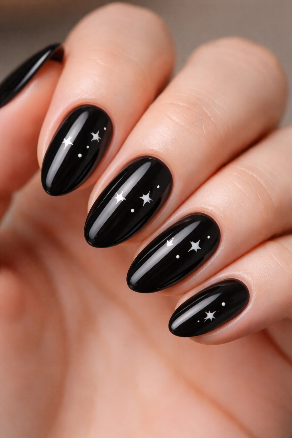 Short black almond nails with tiny white star accents