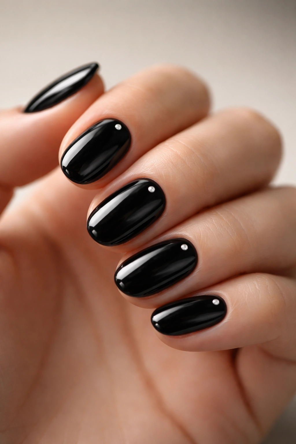 Close-up of short black nails with tiny silver dots on each nail