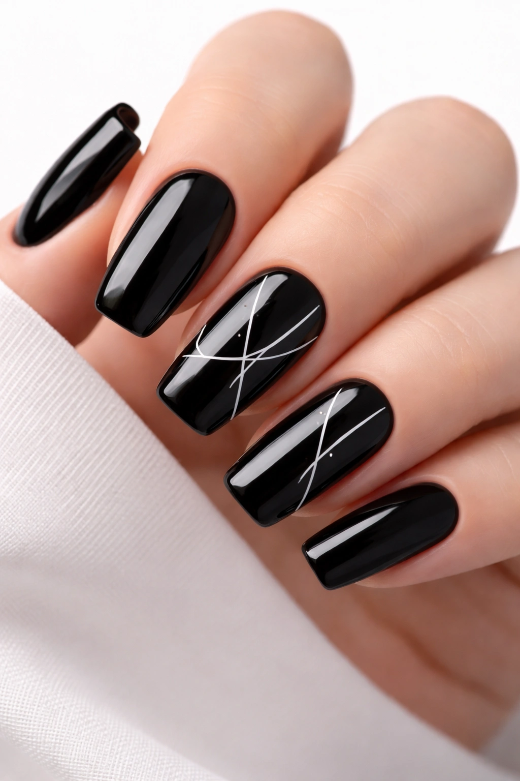 Jet-black rounded-square nails with white minimalist line art on accent nails
