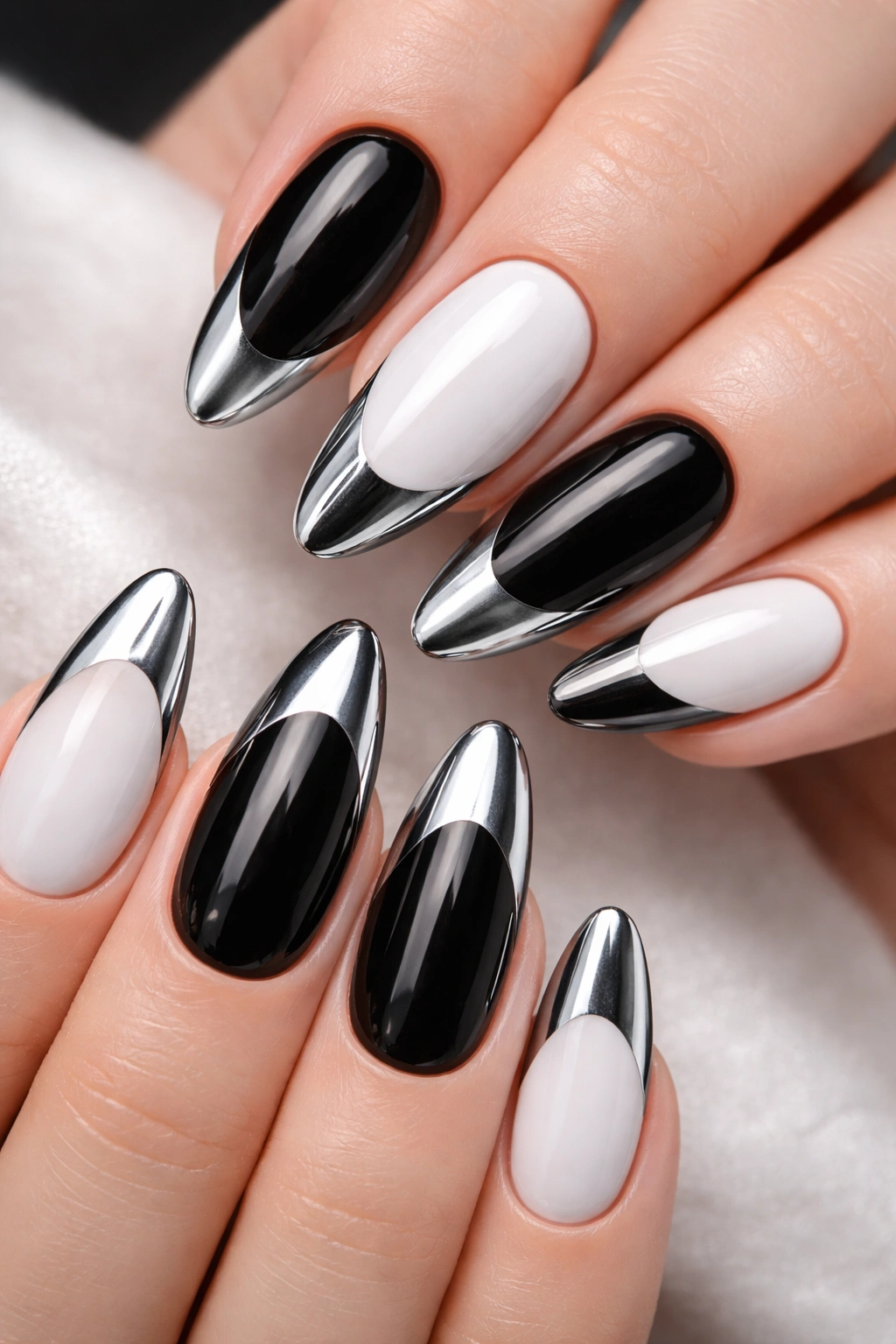 Nails showing alternating black with white chrome tips and white with black chrome tips