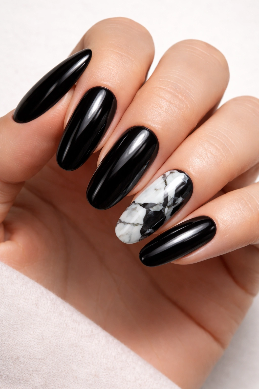 Black nails with white marble veining on a long rounded nail