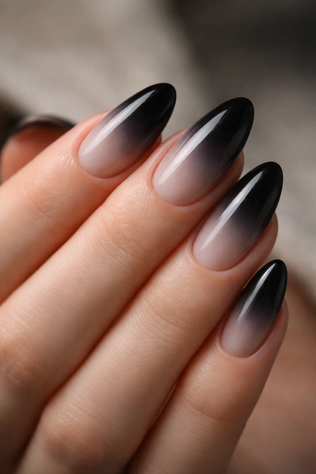 Short almond nails with black ombre fade from pale to black