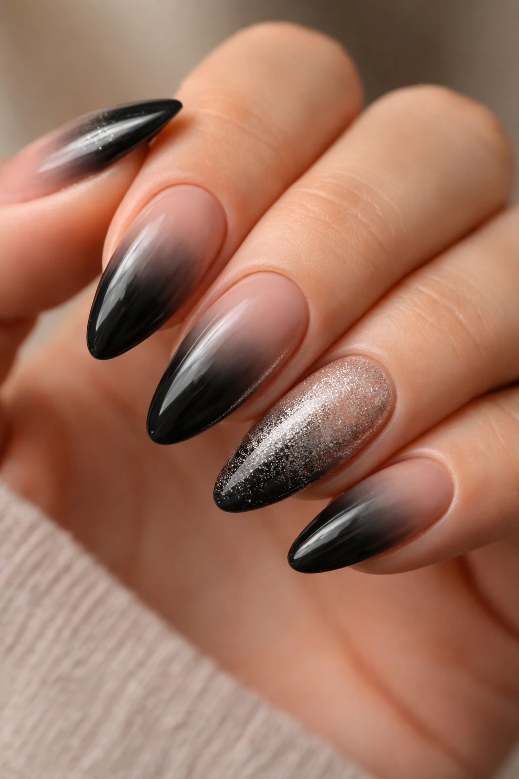 Close-up of almond nails with four black ombre and one accent nail