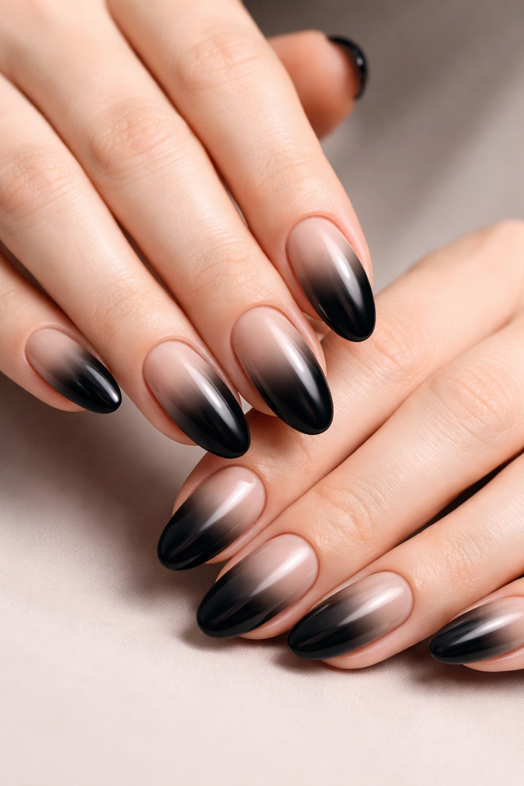 Close-up of black to nude ombre nails on oval nails