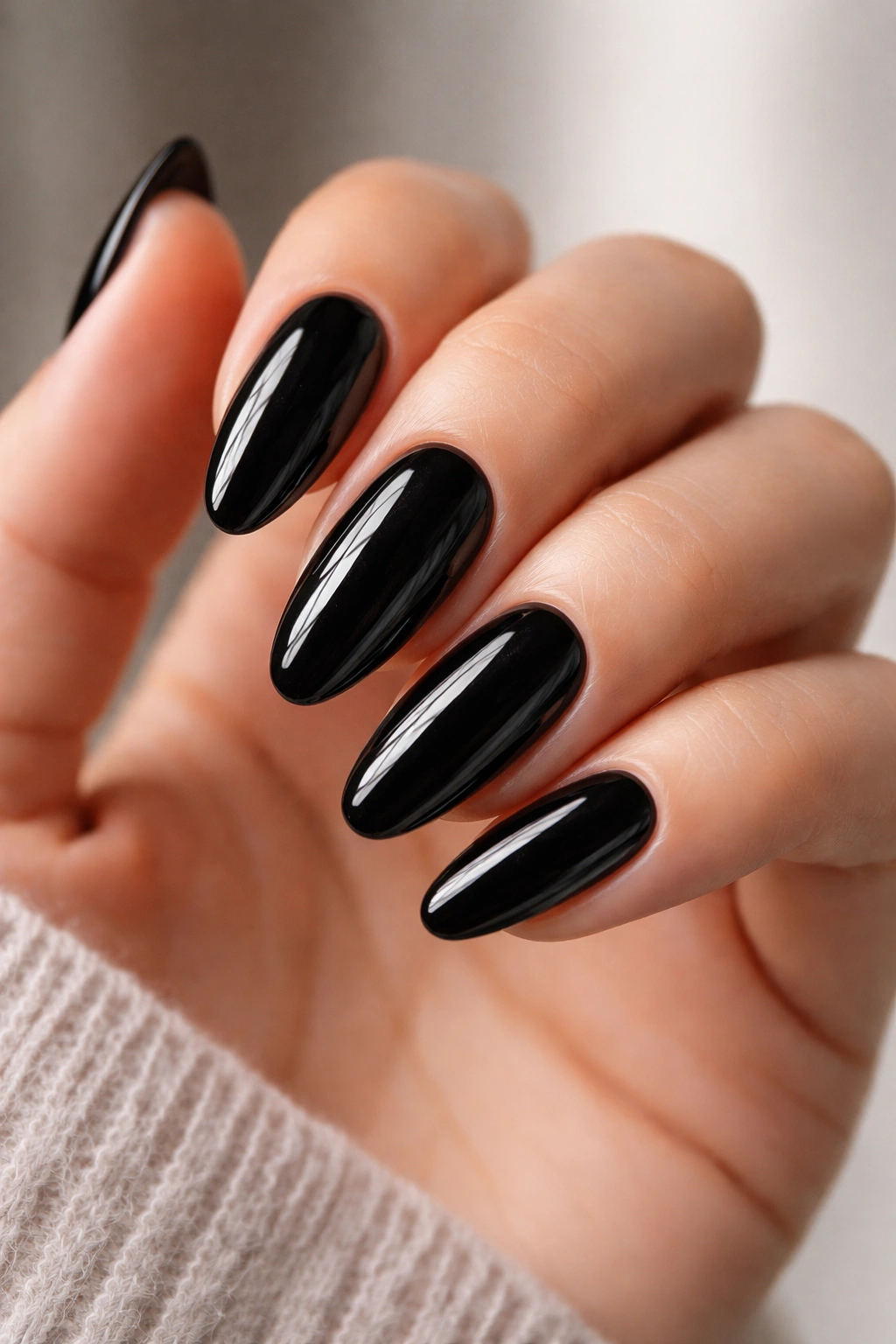 Close-up of long black oval nails with crisp edges and glossy finish
