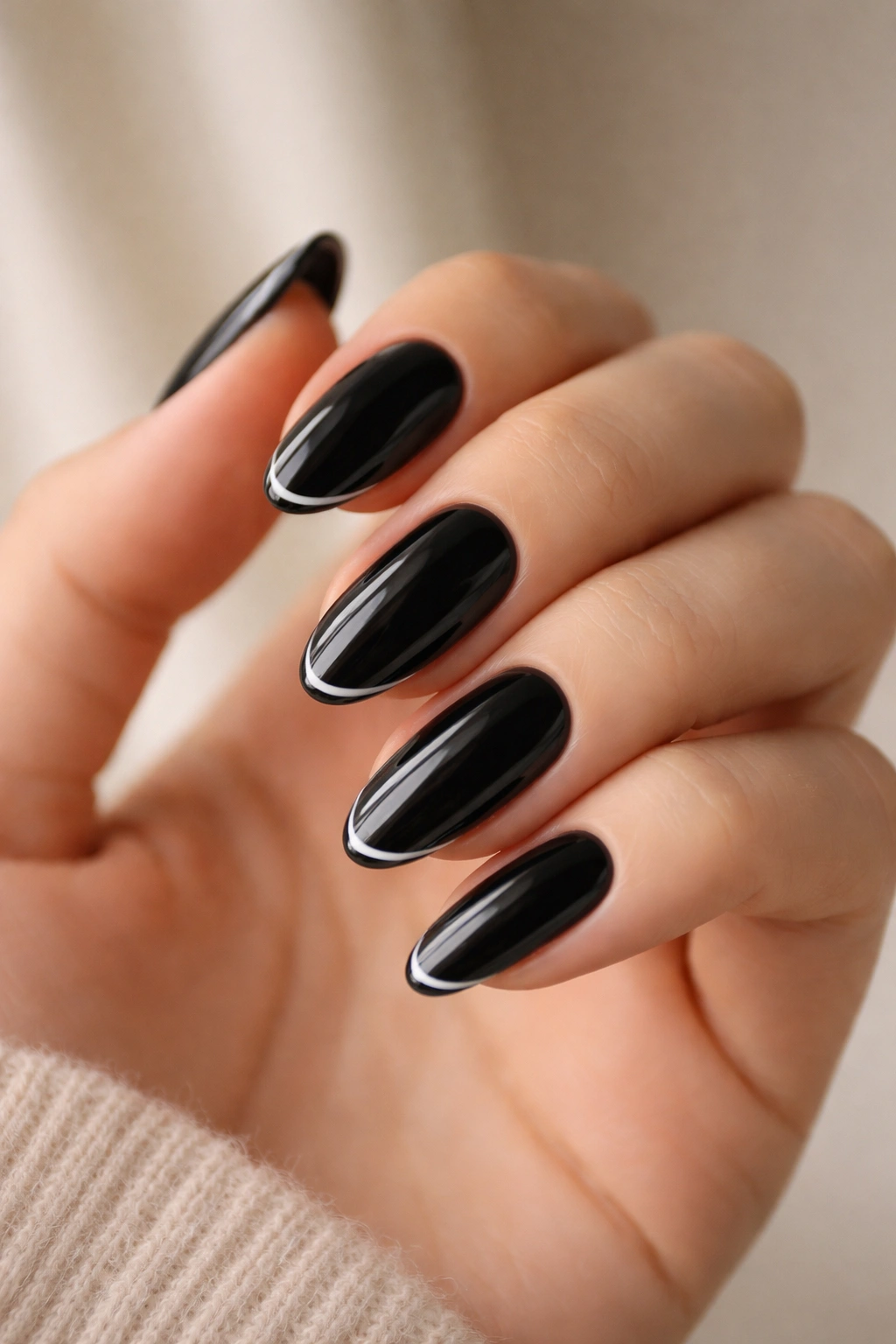 Close-up of black oval nails with micro French tips