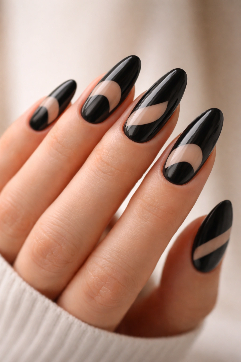 Close-up of long black oval nails featuring clear negative-space accents at cuticle and center