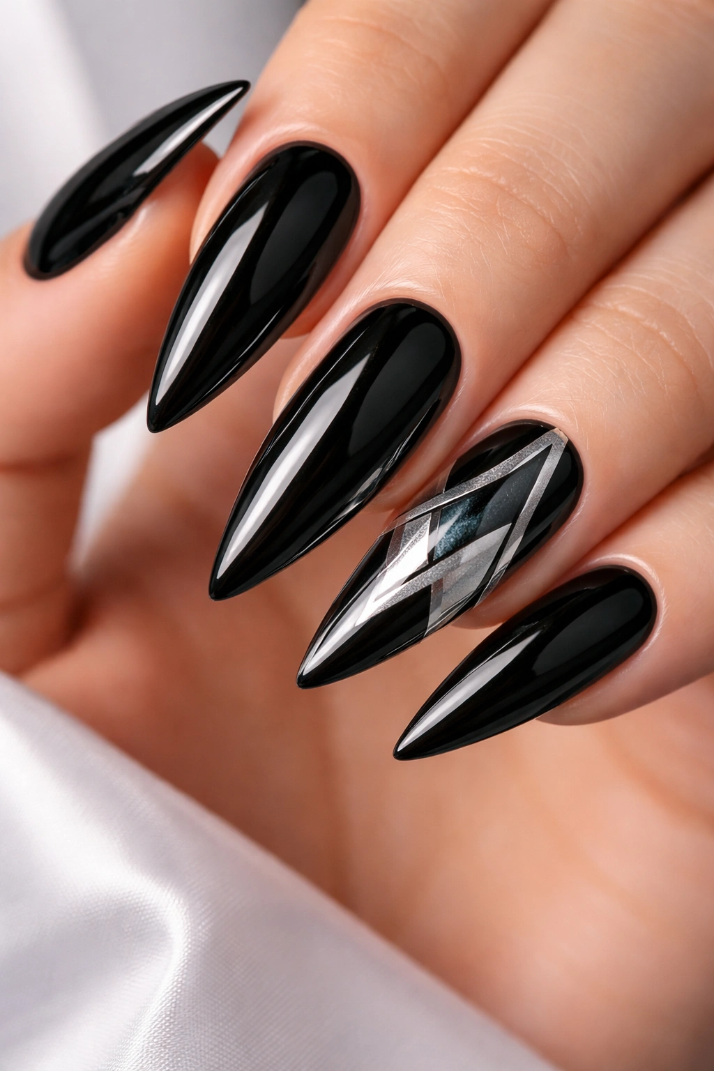 Close-up of black stiletto nails with silver geometric accent nails