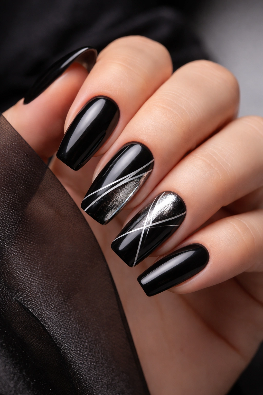 Close-up of black nails with thin silver chrome lines