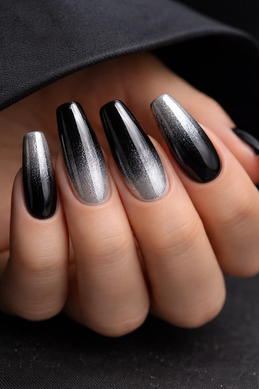 Close-up of black to silver ombre nails on medium coffin shape with glossy finish