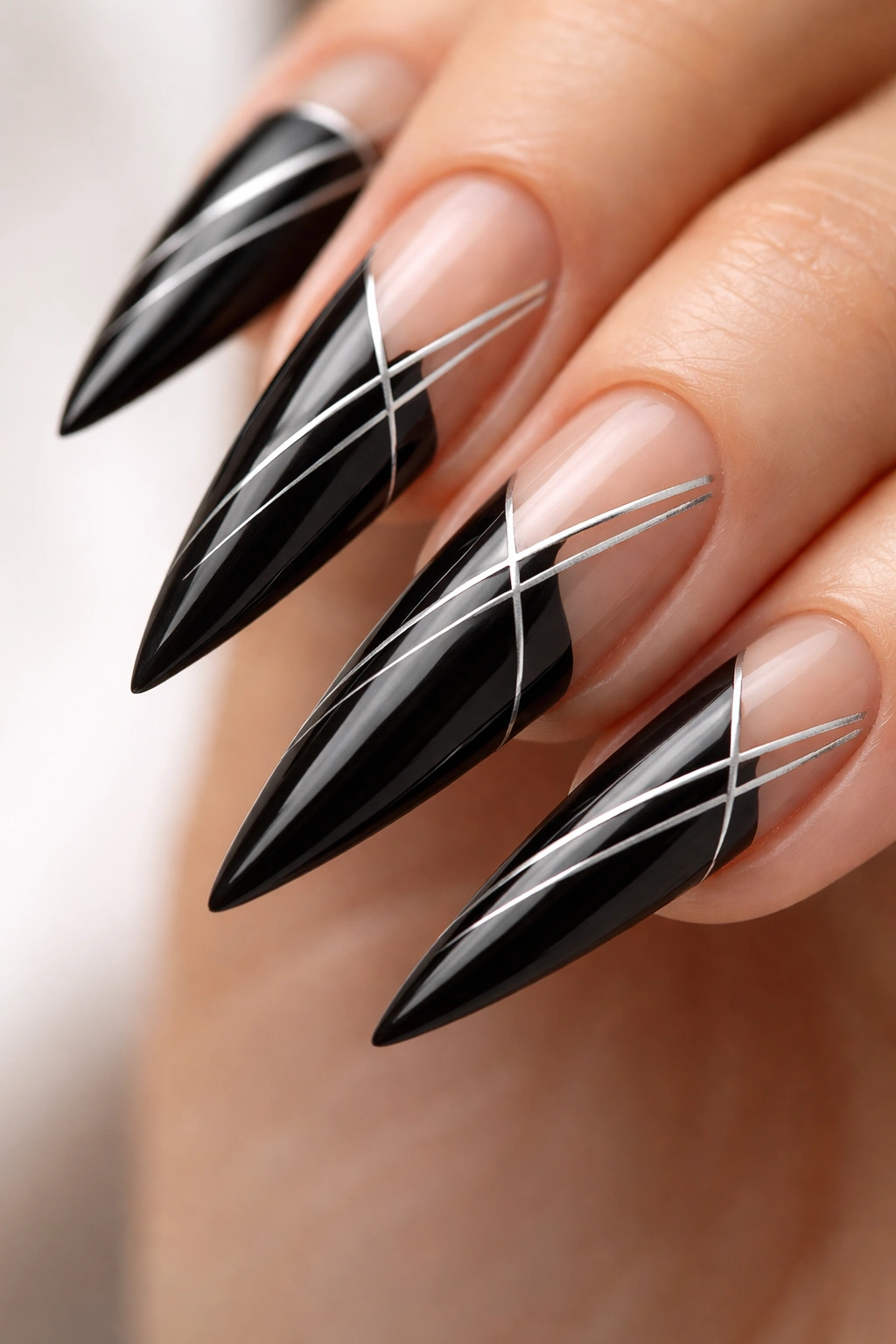 Close-up of black nails with thin silver striping and negative space