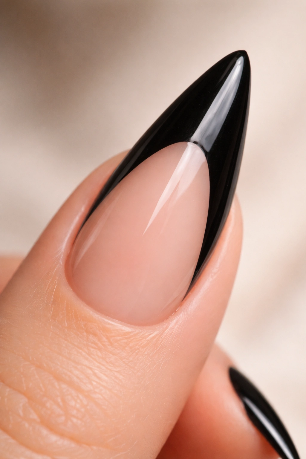 Close-up of black stiletto nail with negative space French tip showing natural nail at tip