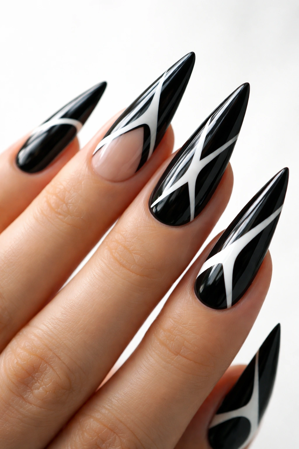 Close-up of black stiletto nails with white negative space design