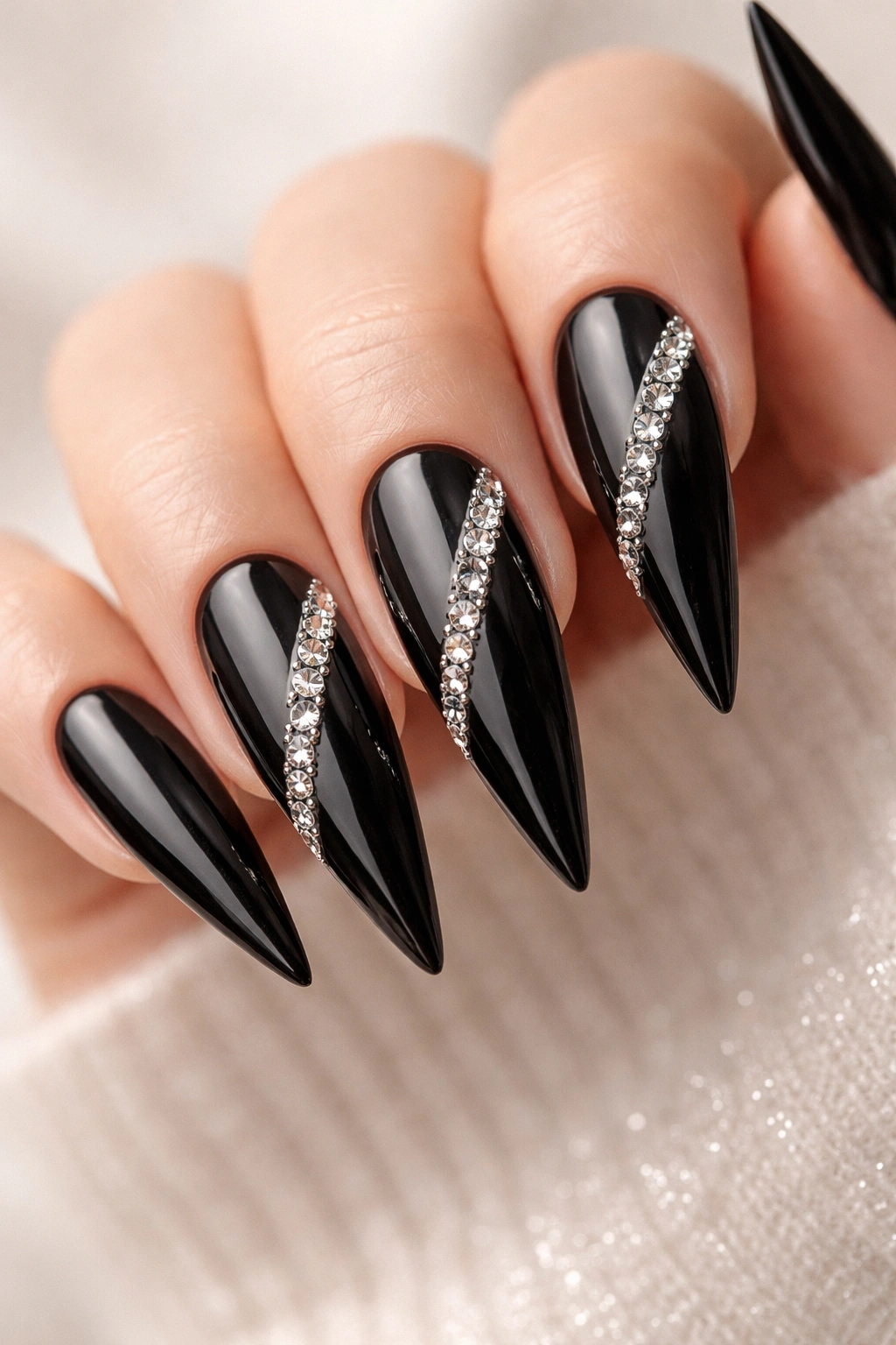 Close-up of black stiletto nails with rhinestone accents