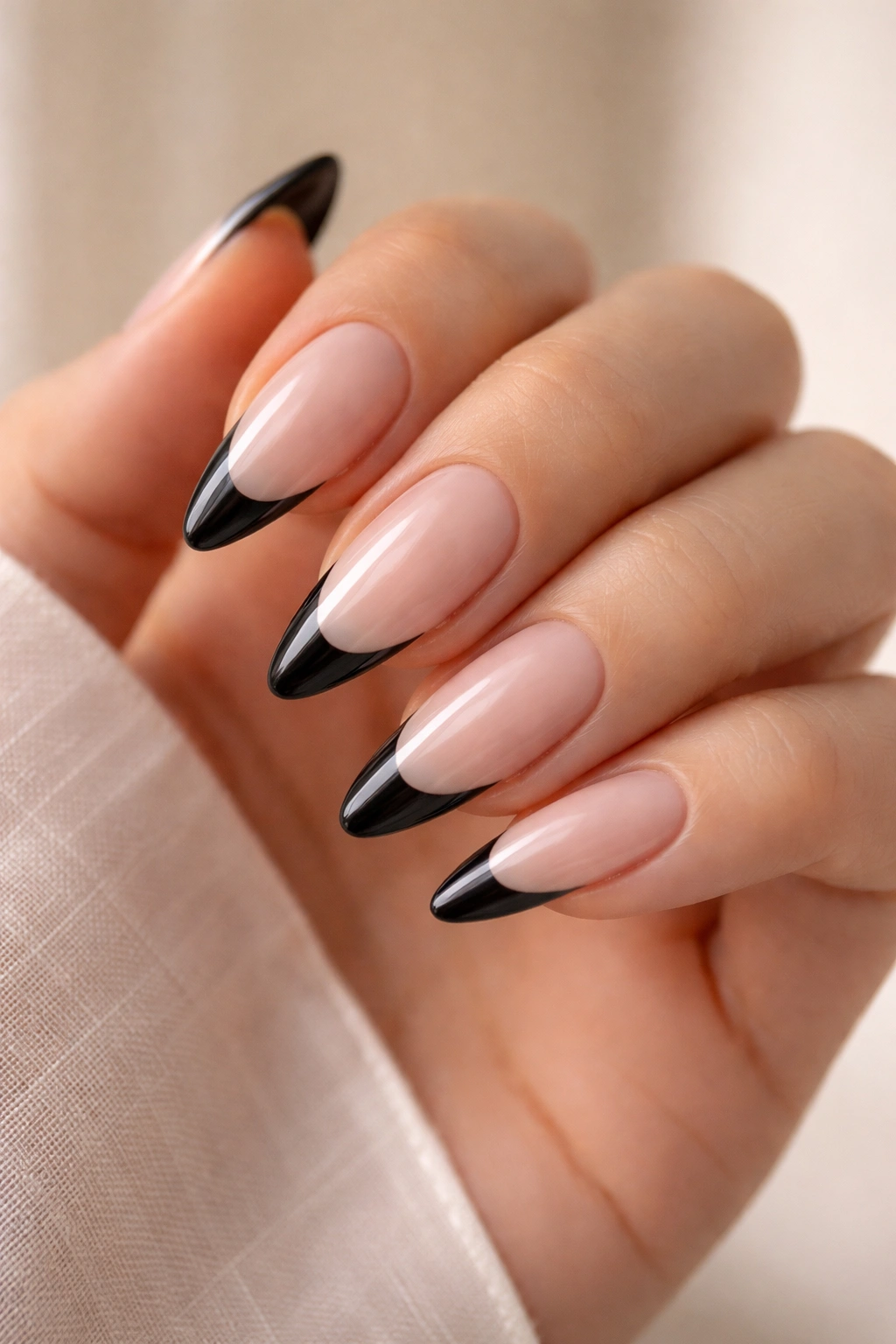 Almond nails with black tips on a sheer base